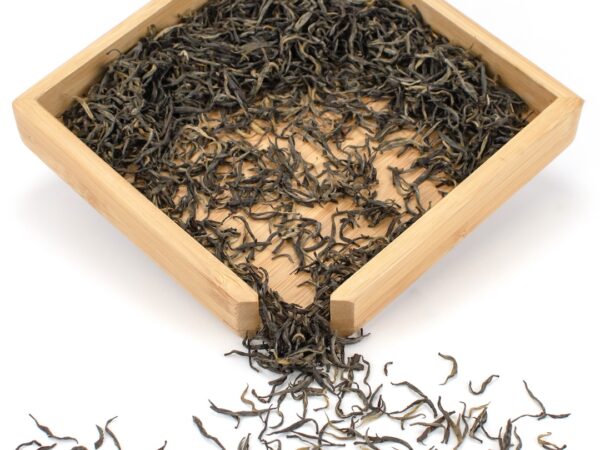 Jin Jun Mei (Champion Steed) black tea dry leaves in a wooden display box.