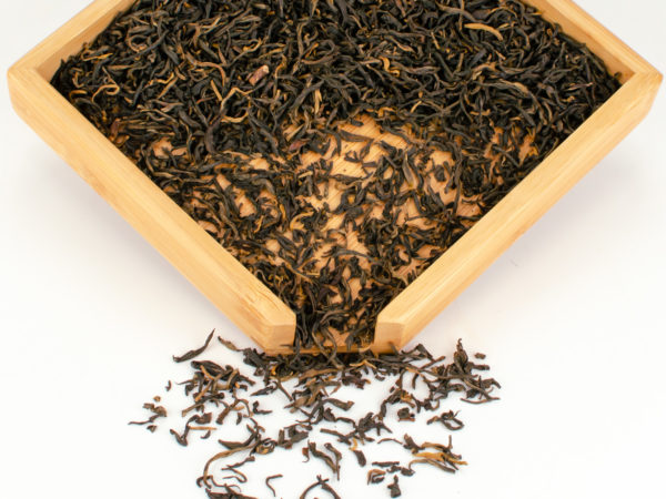 Dianhong Gongfu black tea dry leaves in a wooden display box.