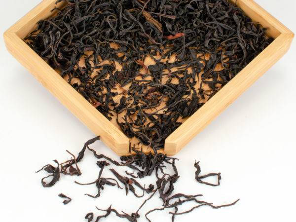 Laoshu Dianhong (Old Tree Yunnan) black tea dry leaves in a wooden display box.