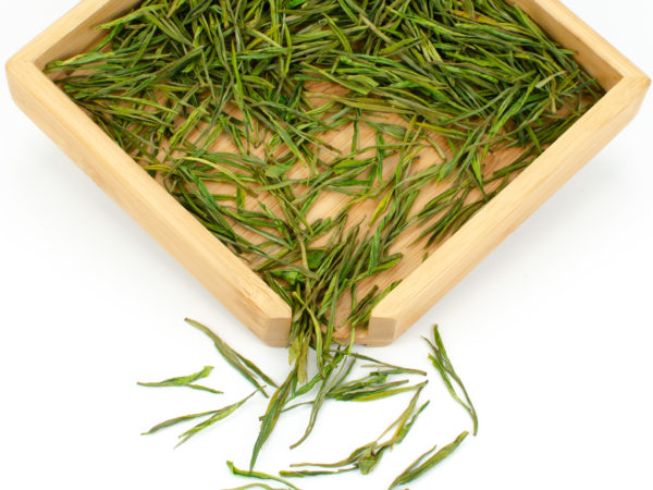 Yu Qian Anji Baicha (Spring Rain Harvest Anji) dry green tea leaves displayed on a bamboo tray.