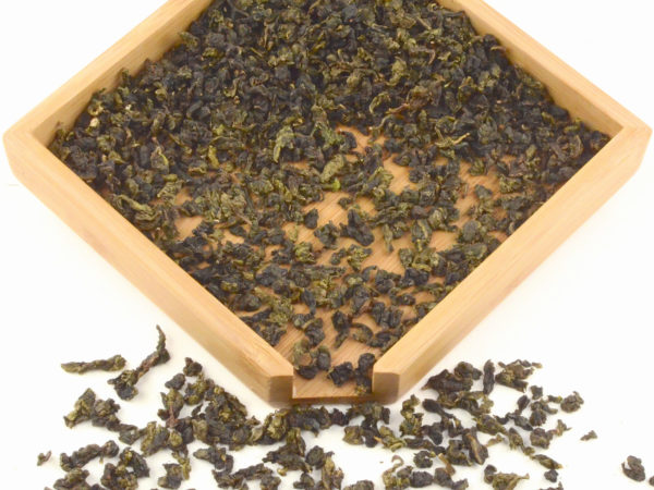 Lilixiang Anxi wulong tea dry leaves in a wooden display box.