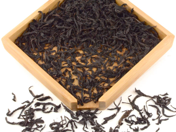 Rougui rock wulong tea dry leaves in a wooden display box.