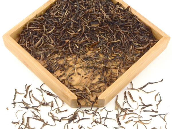Youle Shan (Youle Mountain) sheng puer tea dry leaves in a wooden display box.