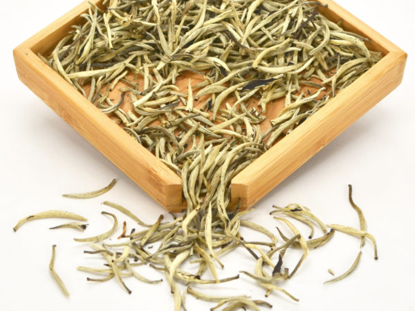 Bailongxu (White Dragon Whiskers) puer tea dry leaves in a wooden display box.