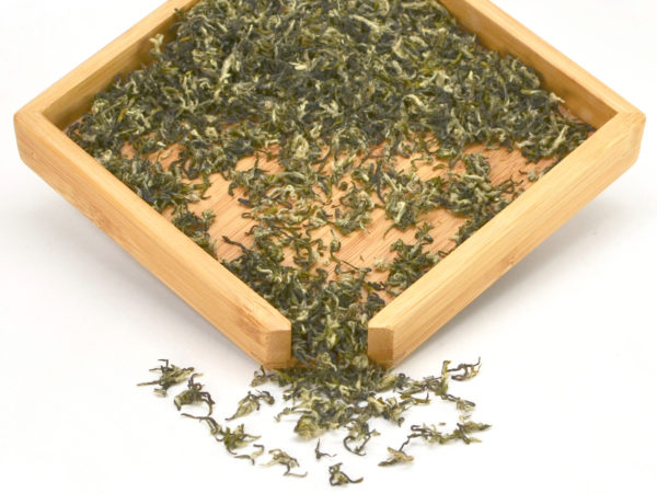 First Pluck Bi Luo Chun green tea dry leaves in a wooden display box.