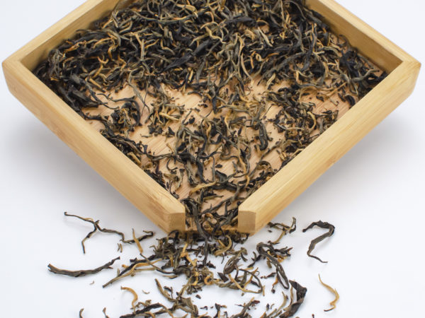Tippy Reserve black tea dry leaves in a wooden display box.