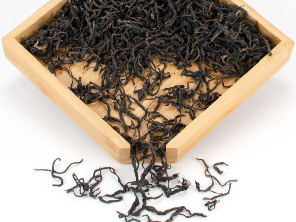 Zijuan Hong (Purple Leaf Yunnan Black) black tea dry leaves in a wooden display box.